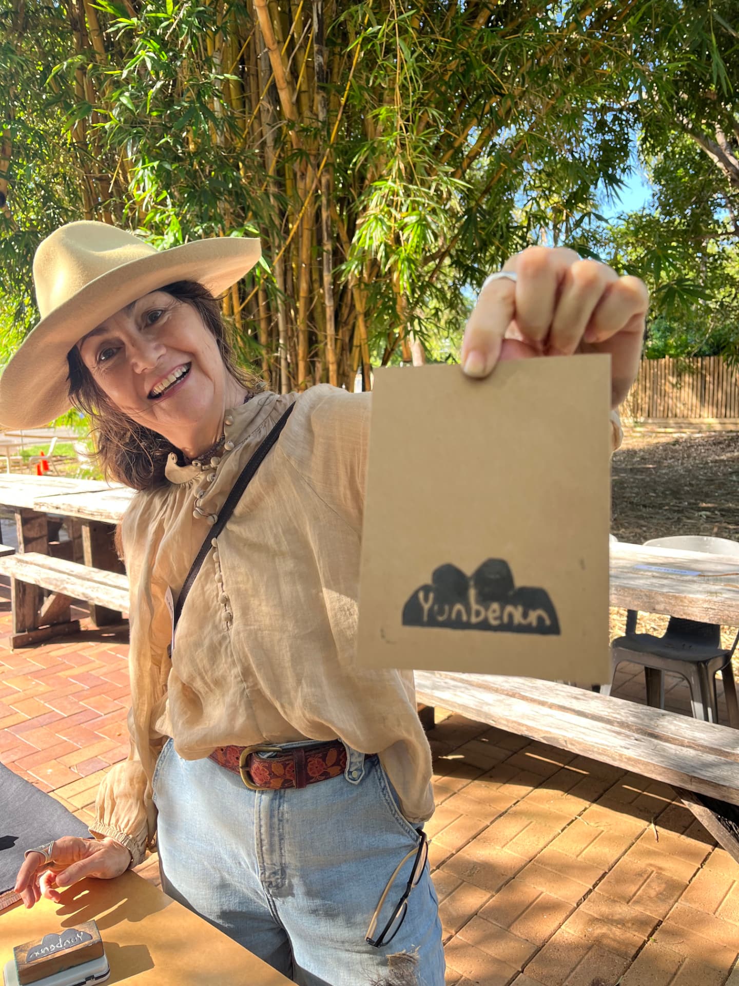 A visitor holding up a hand-stamped Yunbenun print